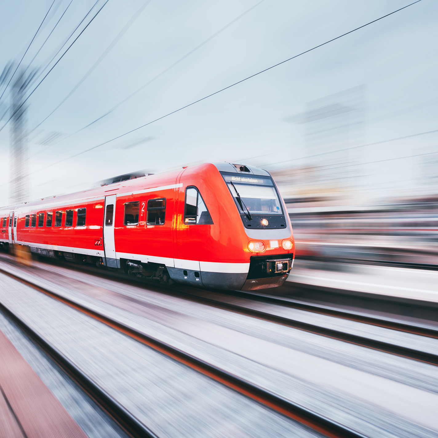 Railway station with modern red passenger train. Industrial landscape